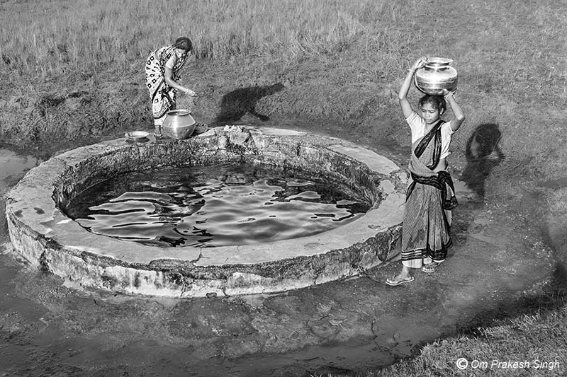 Progressing home with a potful of filtered drinking water procured from the Paata Daarhi in Kudda village, Jharkhand, India